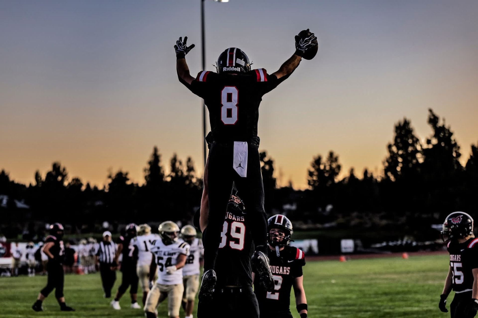 Cougars player is lifted in celebration by a teammate